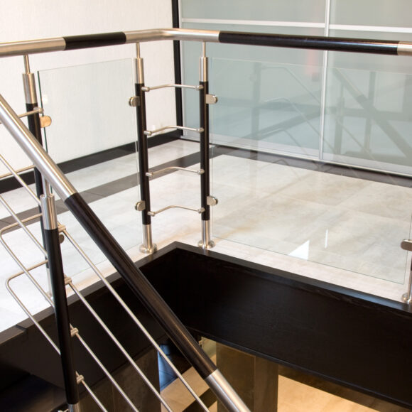 Doppelholmtreppe mit Glasgeländer und Edelstahl-Holz-Kombination